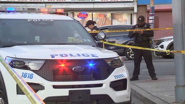Police vehicle and offers at the scene of a shooting in West Philadelphia 