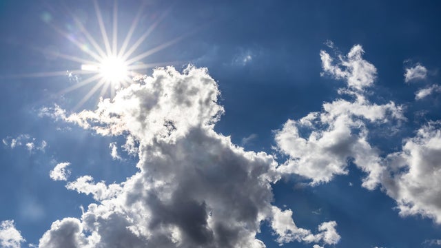 Full bright sun with clouds in the sky 