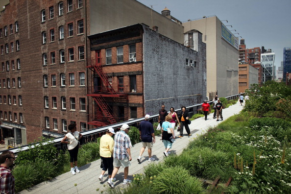 People walk along a path on the newly-opened second section of the High Line park in on June 7, 2011 in New York City. The new section concludes at 30th Street and will add 10 blocks, doubling the length of the High Line to one mile. The original section opened in June 2009 and runs from Gansevoort Street to 20th Street. The High Line was formerly an elevated railway 30 feet above the city's West Side that was built in 1934 for freight trains hauling dairy products, produce and meats and had become dilapidated after the rail closed in 1980. (Photo by Spencer Platt/Getty Images)