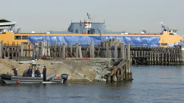 NEW YORK - OCTOBER 16: Police officials survey a damaged pier at the Staten Island ferry terminal October 16, 2003 on Staten Island. Authorities are investigating whether a ferry pilot lost consciousness during a trip across a windy New York Harbor before the ferry slammed into a pier, killing 11 people and injuring 42 others. (Photo by Mike Hvozda/NTSB via Getty Images)