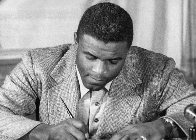 NEW YORK, UNITED STATES:  (FILES)This undated file photo shows US baseball star Jackie Robinson as he signs a then-record contract to play for the Brooklyn Dodgers in New York. Robinson has been chosen to receive posthumously the Congressional Gold Medal, the highest award Congress can bestow on a US civilian, 02 March 2005, for his accomplishments on the baseball diamond, as well as "his lifetime of breaking down barriers and his unending fight for justice," officials on Capitol Hill said in an earlier press release. US Senator John Kerry and US Representative Richard Neal, who co-sponsored legislation honoring Robinson, will be joined by the ballplayer's widow Rachel Robinson, US President George W. Bush and congressional leaders at the ceremony. Robinson broke baseball's "color line", becoming the first African American to play in the Major Leagues when he debuted with the Brooklyn Dodgers in 1947. Officials in Congress said however that he is also being honored for his contributions to the broader struggle for civil rights. 