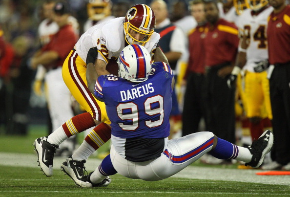 TORONTO, ON - OCTOBER 30: John Beck #12 of the Washington Redskins is sacked during NFL game action by Marcell Dareus #99 of the Buffalo Bills at Rogers Centre on October 30, 2011 in Toronto, Ontario, Canada. (Photo by Tom Szczerbowski/Getty Images)