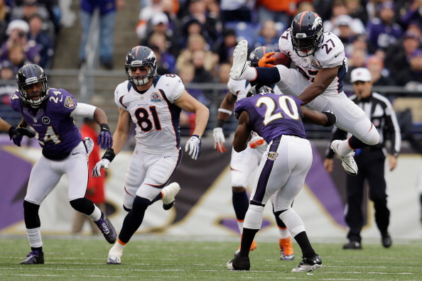 BALTIMORE, MD - DECEMBER 16: Running back Knowshon Moreno #27 of the Denver Broncos jumps over free safety Ed Reed #20 of the Baltimore Ravens while rushing the ball during the first half at M&T Bank Stadium on December 16, 2012 in Baltimore, Maryland.  (Photo by Rob Carr/Getty Images)