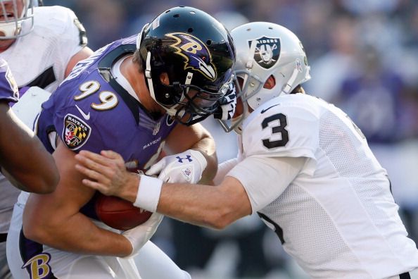 BALTIMORE, MD - NOVEMBER 11:  Quarterback Carson Palmer #3 of the Oakland Raiders tackles linebacker Paul Kruger #99 of the Baltimore Ravens after Kruger intercepted Palmer's pass during the first half of their gameat M&T Bank Stadium on November 11, 2012 in Baltimore, Maryland.  (Photo by Rob Carr/Getty Images) 