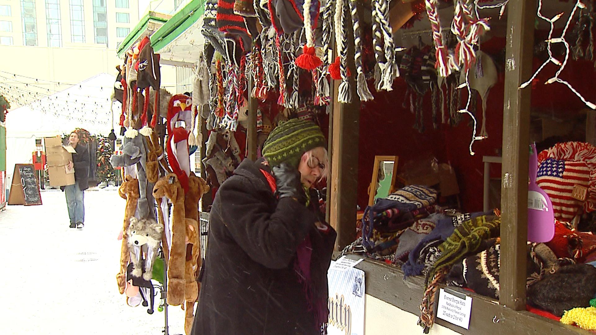 A woman trying on a winter hat at the Christkindl Market (credit: CBS)